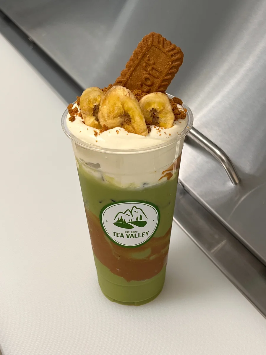 Banana Biscoff Matcha topped with banana cream and Biscoff crunch